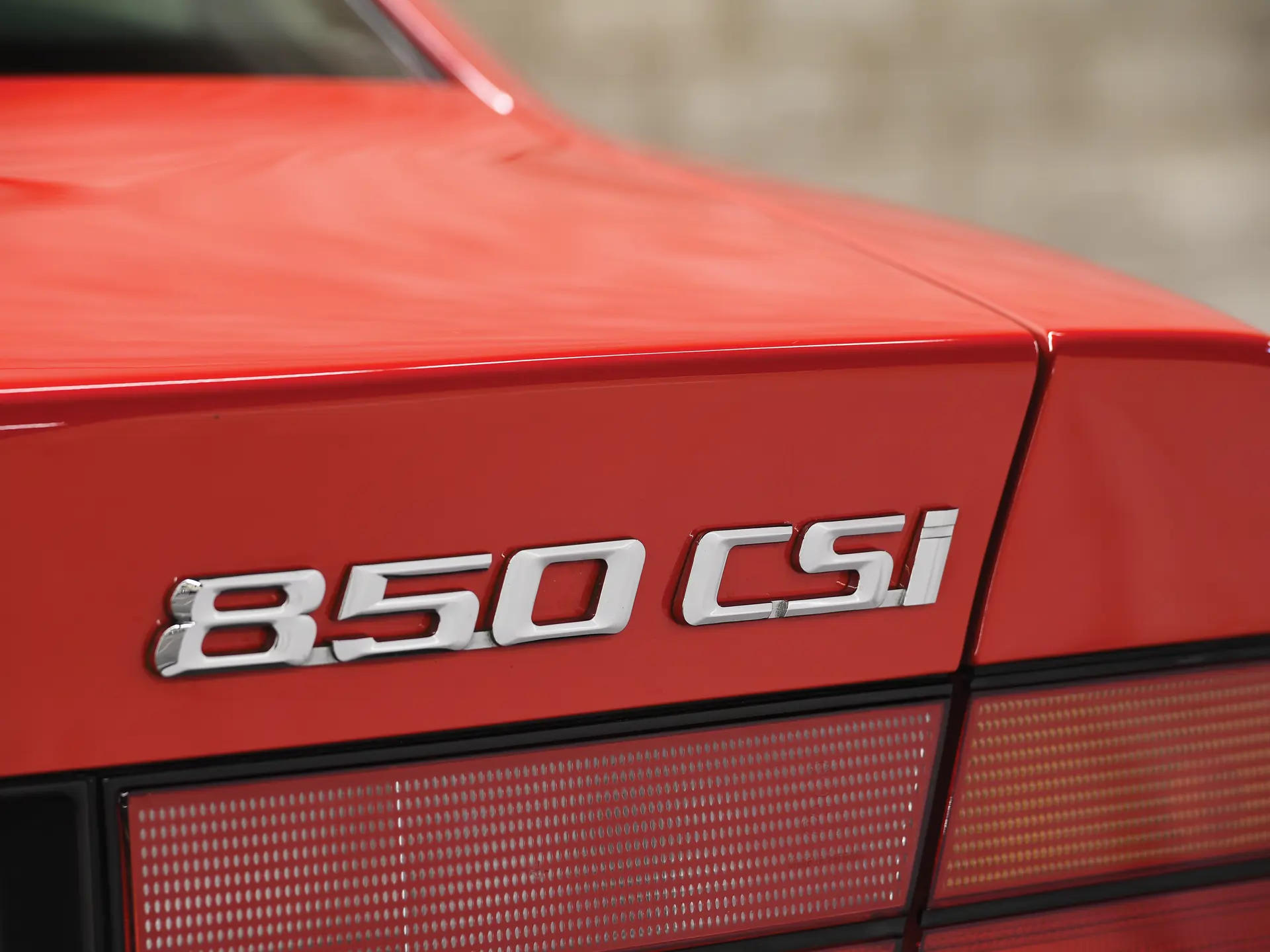 Up-close shot of the badge of a BMW 850CSi on the right side of its trunk