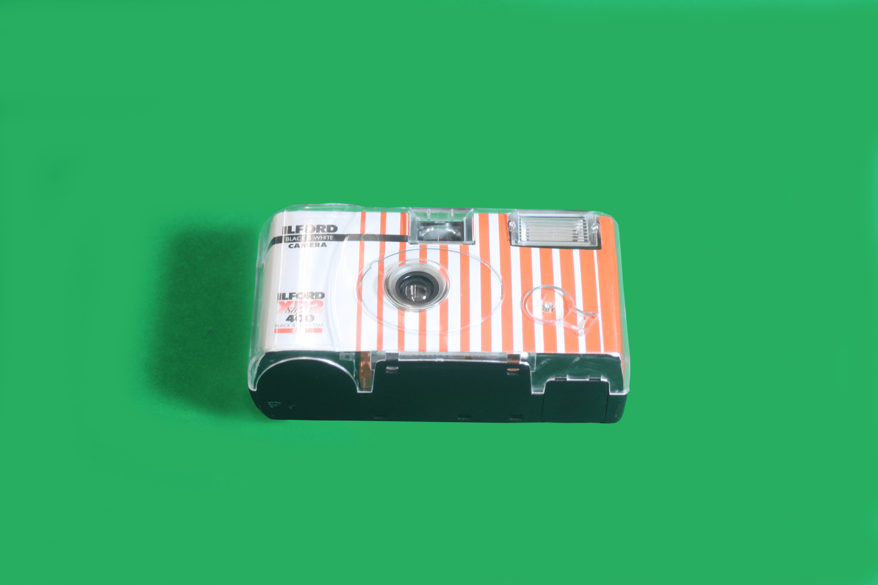 A small camera lies atop a green table.